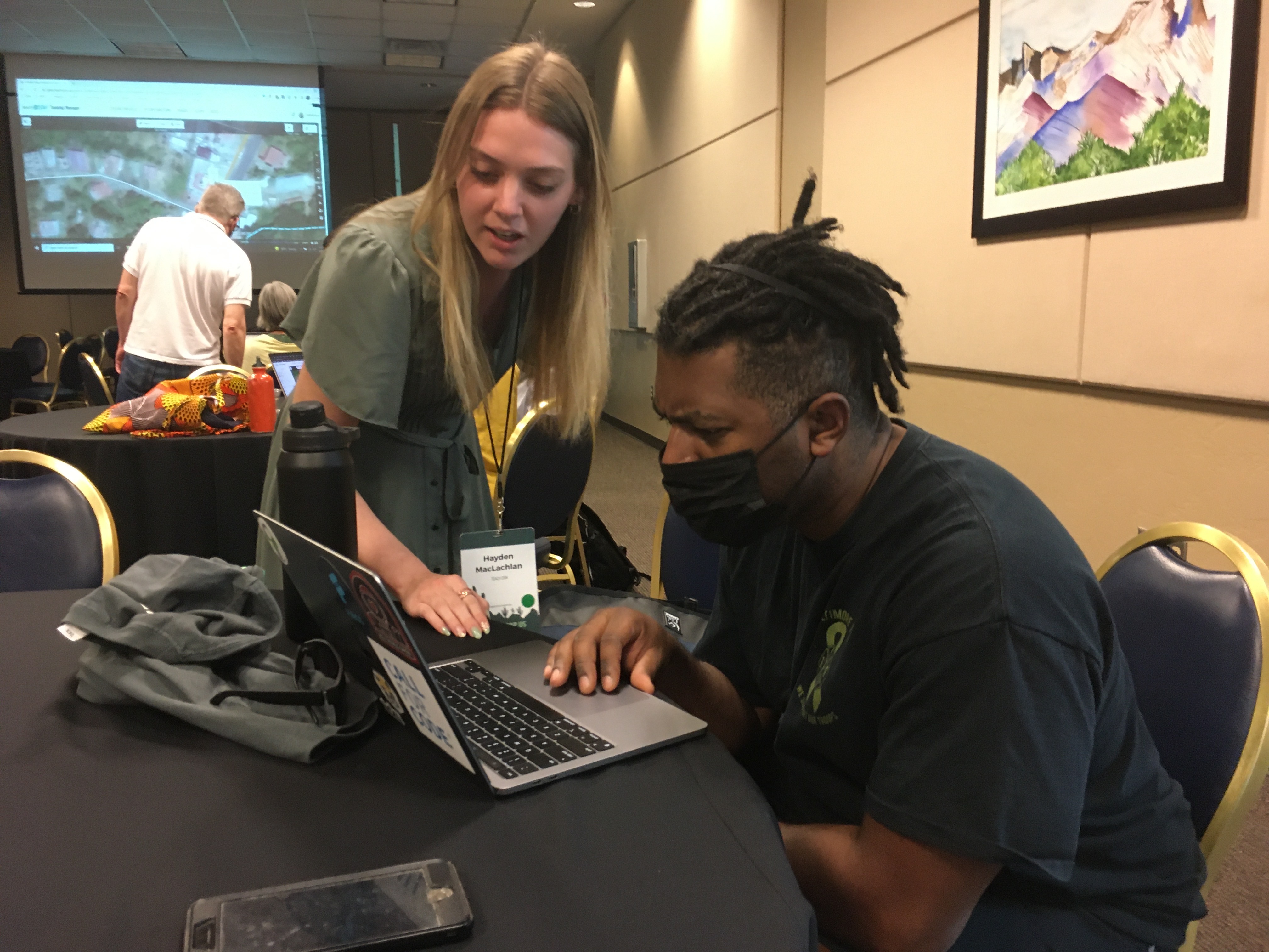 Hayden MacLachlan assisting a new mapper during a TeachOSM workshop at State of the Map US 2022.